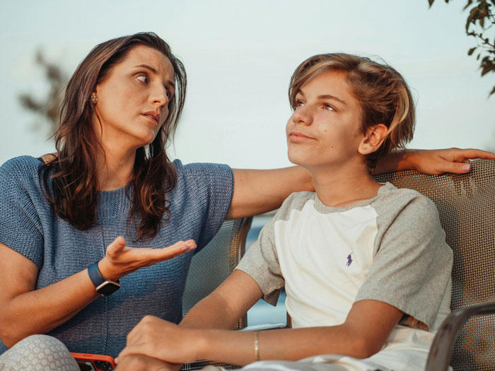 A woman having a serious talk with a teenage boy, illustrating refusing to establish relationship with fathers and kids. A woman having a serious talk with a teenage boy, illustrating refusing to establish relationship with fathers and kids.