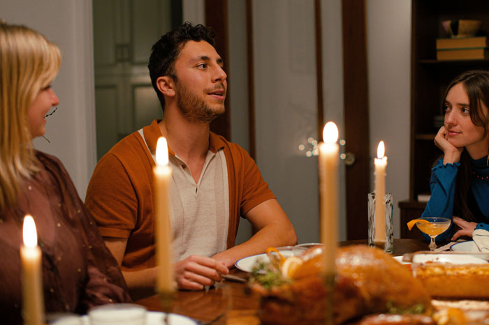 Family dining at candlelit dinner table, illustrating step-grandpa conflict over denying candy to child. Family dining at candlelit dinner table, illustrating step-grandpa conflict over denying candy to child.