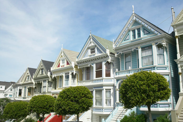 Row of Victorian houses in a neighborhood with neatly trimmed lawns highlighting HOA grass height dispute and neighbor retaliation. Row of Victorian houses in a neighborhood with neatly trimmed lawns highlighting HOA grass height dispute and neighbor retaliation.