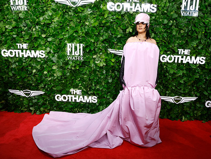 Rihanna in a flowing pink gown and cap on the red carpet sparking wild reactions about a diaper bag at home.