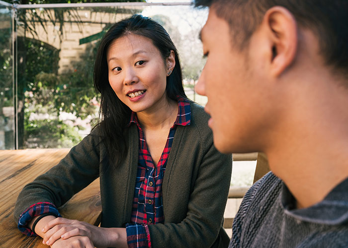 Two women having a conversation outdoors, illustrating reactions to men who say they prefer the no makeup look.