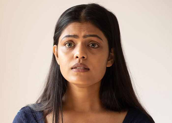 Worried young woman with long dark hair, looking anxious and uncertain about being held hostage at parents’ place. Worried young woman with long dark hair, looking anxious and uncertain about being held hostage at parents’ place.
