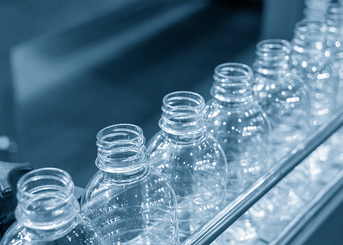 Clear plastic bottles on an assembly line representing microplastics and their impact on bone tissue in scientific research. Clear plastic bottles on an assembly line representing microplastics and their impact on bone tissue in scientific research.