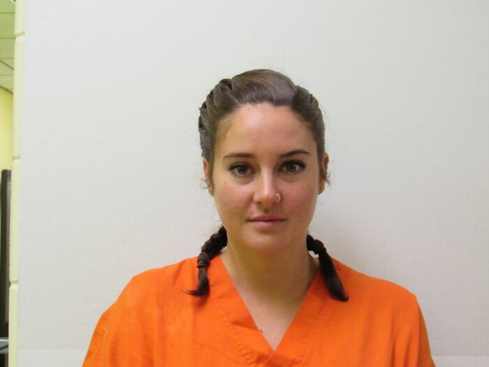 Female celebrity mugshot wearing an orange jumpsuit, looking directly at the camera for infamous celebrity mugshots.