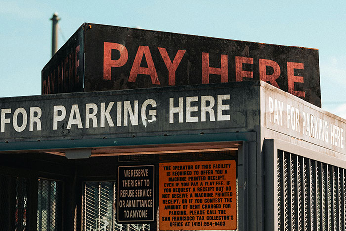 Old parking payment booth with signs, illustrating wily criminals who cleverly outsmarted police officers.
