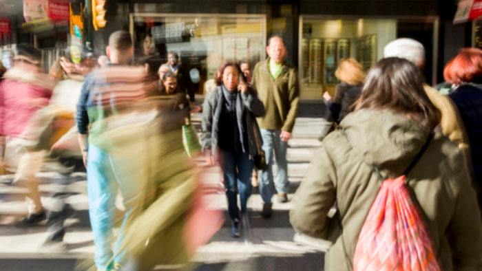Blurred crowd crossing a busy street illustrating psychological cheat codes that make social life easier and interactions smoother.