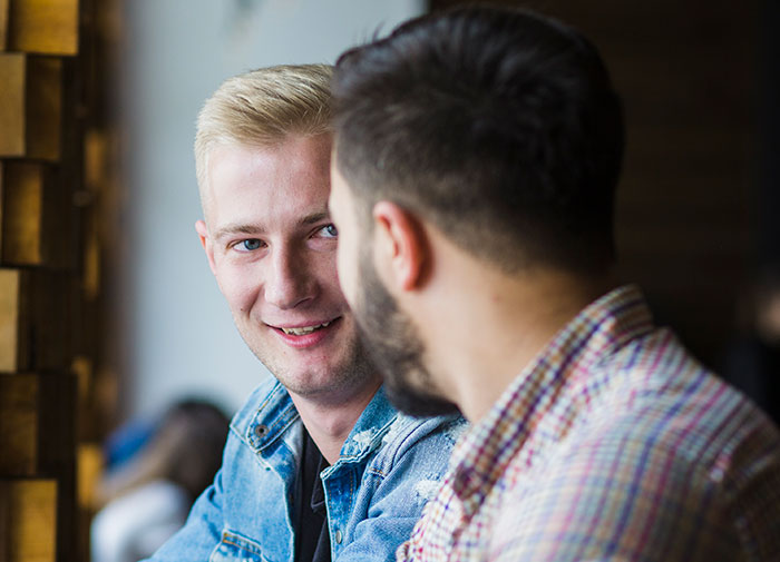Two men engaging in a friendly conversation using psychological cheat codes to navigate social situations effectively.