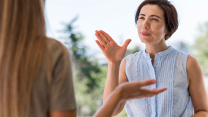 Two women using psychological cheat codes while engaging in a meaningful social conversation outdoors.