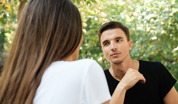 Two people having a thoughtful conversation outdoors, demonstrating psychological cheat codes for easier social life.