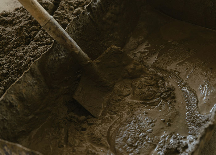 Shovel mixing wet cement in a tray, symbolizing diabolical revenge stories from people you wouldn’t want as enemies.