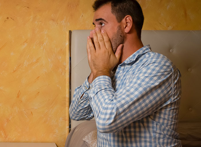 Man in a blue checkered shirt showing surprise and disbelief, illustrating things people believe only after experiencing them.
