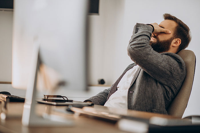 Man in office showing stress and frustration, illustrating things people never took seriously until experienced themselves