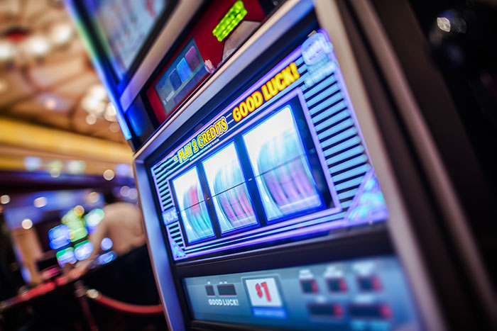 Slot machine lit up in a casino with play credits and good luck message, illustrating experiences people believe in once it happens.