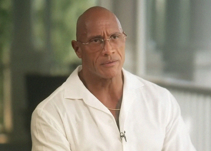 Man in a white shirt and glasses sharing experiences about celebrities they’ve met and the vibes they gave off in an interview setting.