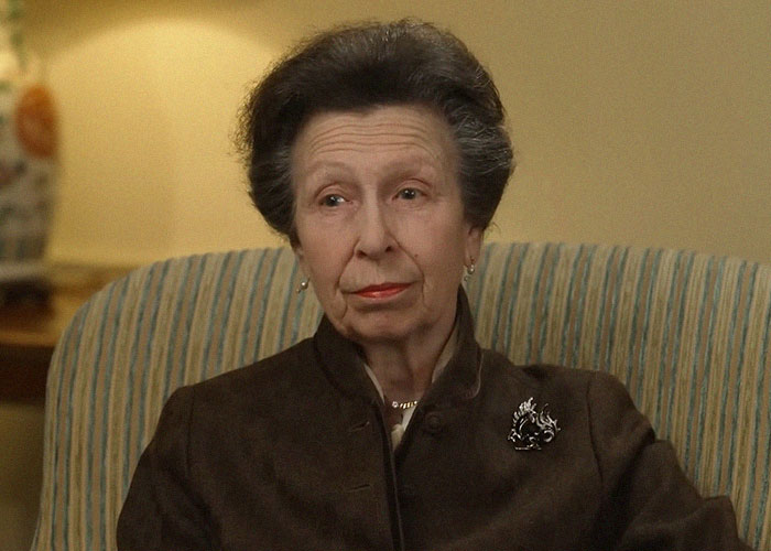 Older woman with short hair sitting in a striped chair, sharing stories about celebrities they’ve met and their vibes.