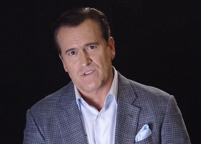 Actor Bruce Campbell wearing a blue blazer and light blue shirt, sharing stories about celebrities and the vibes they gave off.