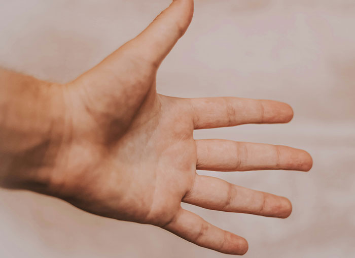Close-up of a human hand with fingers spread, illustrating aspects of the mammalian dive reflex in the human body.