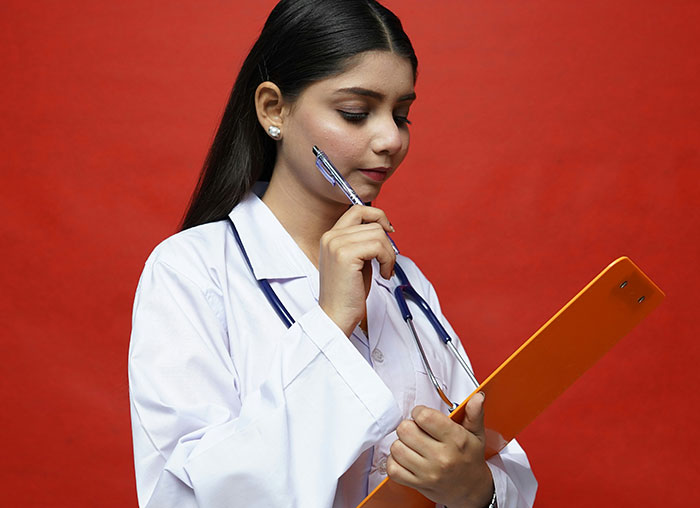 Young female doctor in white coat with stethoscope holding clipboard, illustrating human body facts about mammalian dive reflex.