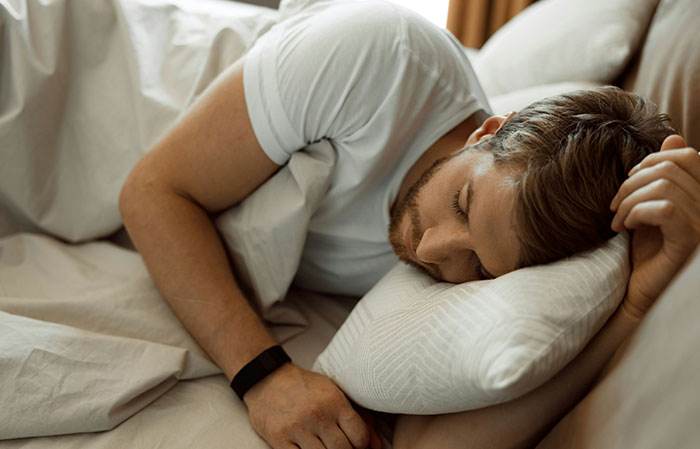 Man sleeping peacefully in bed demonstrating relaxation linked to the mammalian dive reflex in the human body.