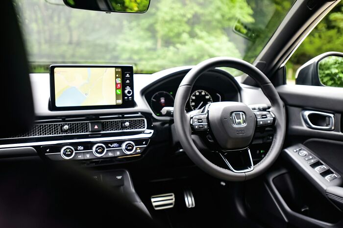 Interior view of a car highlighting small design mistakes in dashboard layout and steering wheel controls causing user frustration.