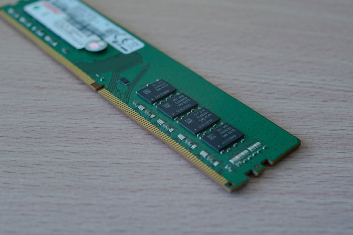 Close-up of a computer memory module on a wooden surface representing AI industry technology components.