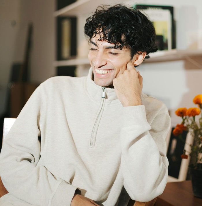 Young secretly gay teen smiling confidently indoors, teaching homophobic parents a lesson on respect in his own way. Young secretly gay teen smiling confidently indoors, teaching homophobic parents a lesson on respect in his own way.