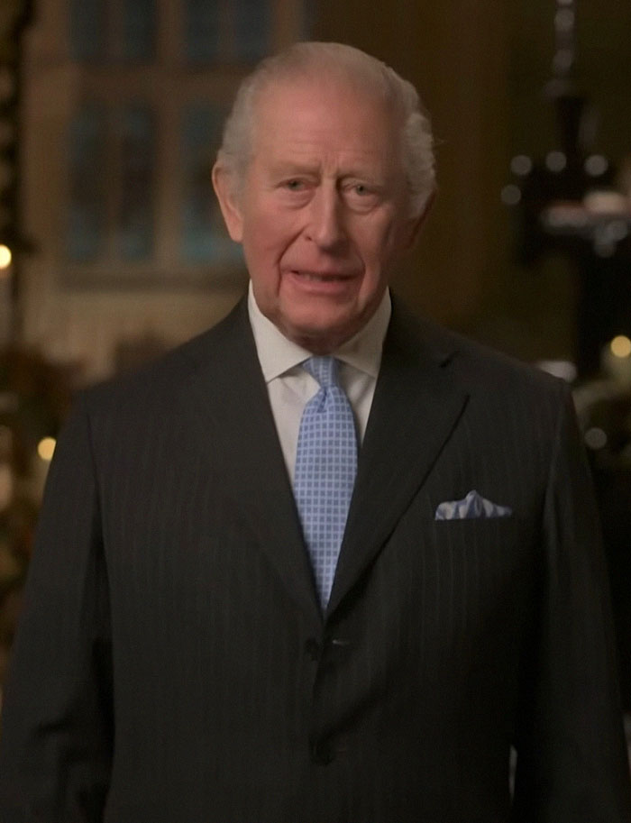 Older man in a dark suit and light blue tie delivering a formal message related to Meghan Markle and Prince Harry split rumors Older man in a dark suit and light blue tie delivering a formal message related to Meghan Markle and Prince Harry split rumors