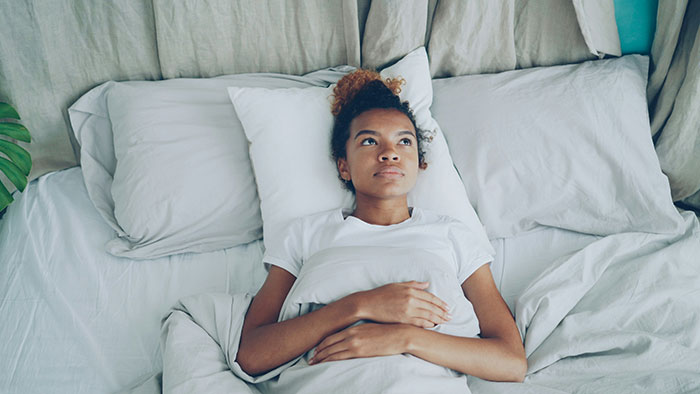 Woman lying in bed looking thoughtful and upset, reflecting on couple’s difficult first free Saturday in ages. Woman lying in bed looking thoughtful and upset, reflecting on couple’s difficult first free Saturday in ages.
