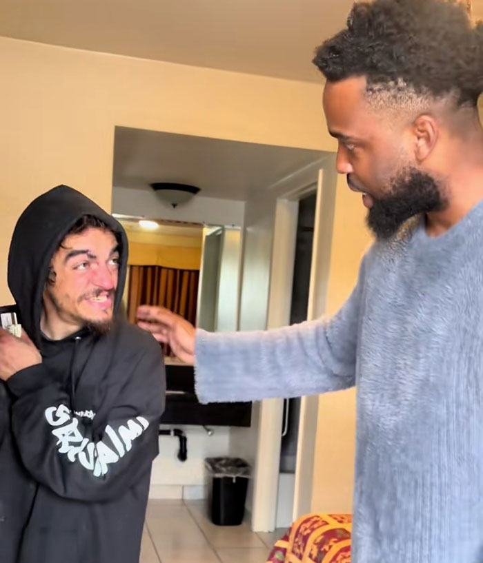 Two men in a motel room, one wearing a black hoodie and the other in a grey sweater, discussing Nickelodeon star's motel stay. Two men in a motel room, one wearing a black hoodie and the other in a grey sweater, discussing Nickelodeon star's motel stay.