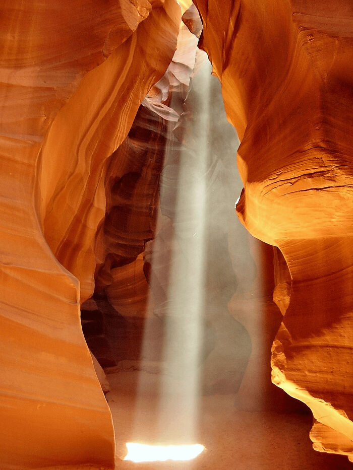 Sunlight beams shining through narrow rock formations in a spectacular place that looks AI generated but is real.