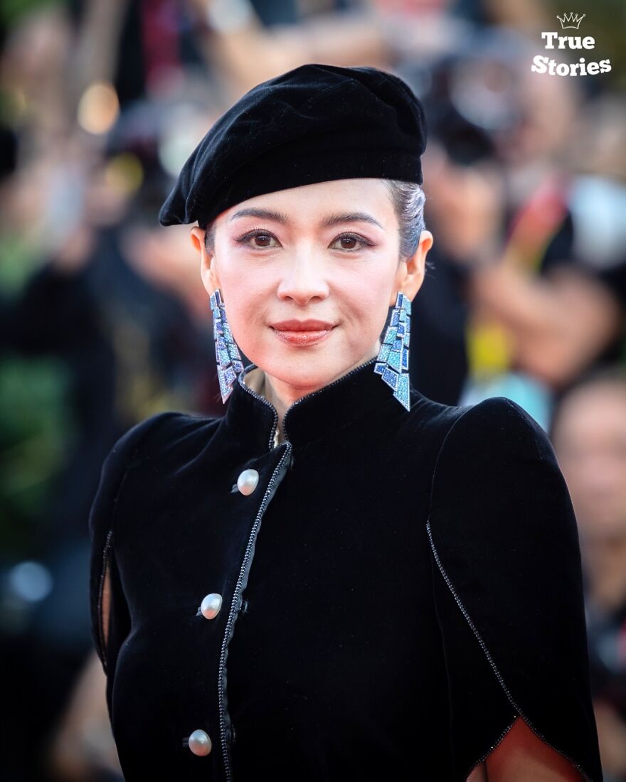 Asian American personality wearing a black beret and statement earrings at a public event for important American personalities.