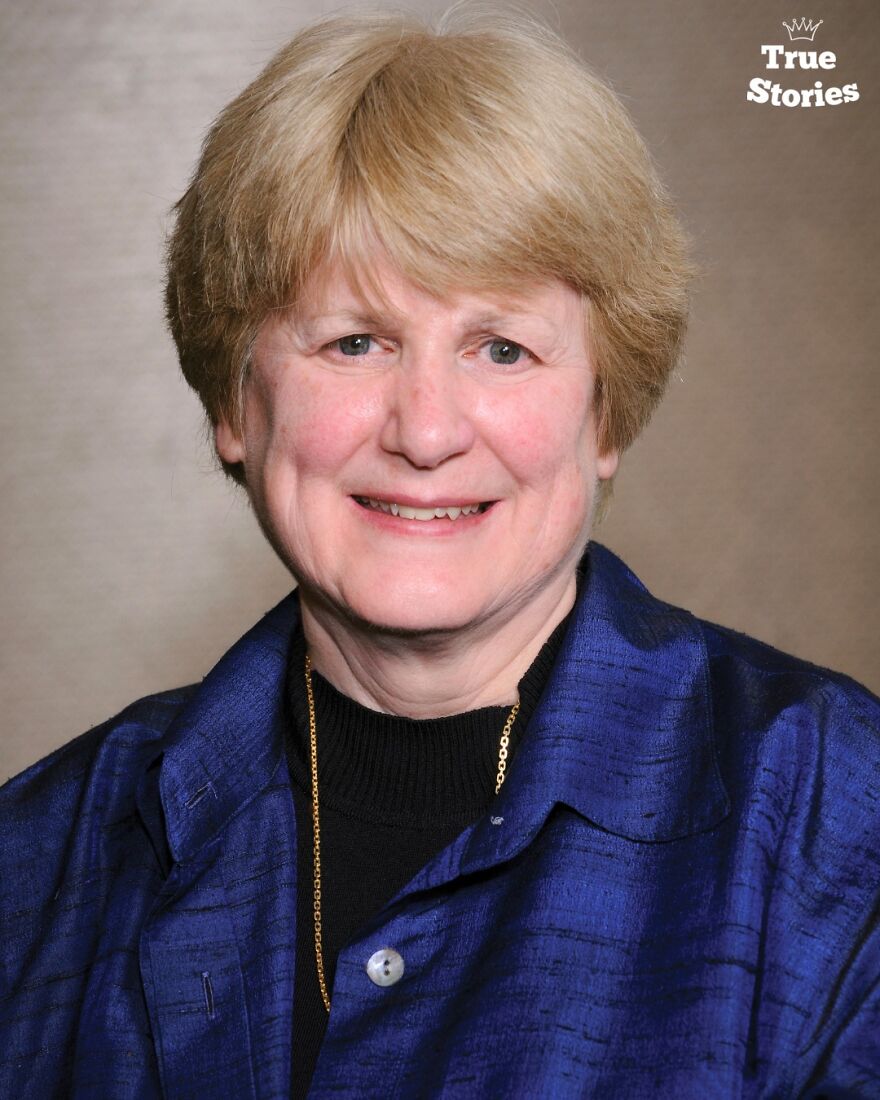 Portrait of an important American personality with short blonde hair wearing a blue jacket and a gold necklace.