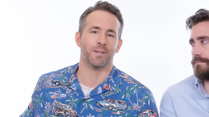 Actor in a colorful tropical shirt speaking while another man listens, illustrating people think celebrities closet skeletons.