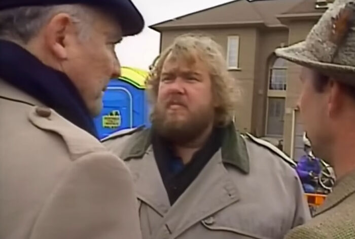 Three men in vintage coats having a serious conversation outdoors, revealing fascinating secrets about celebrities.