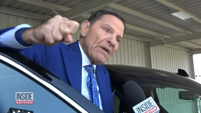 Man in a blue suit angrily speaking to reporters about people think celebrities closet skeletons near a black car.