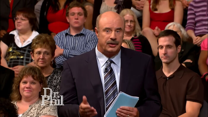 Dr. Phil in a suit speaking to an audience about people think celebrities closet skeletons on a talk show stage.