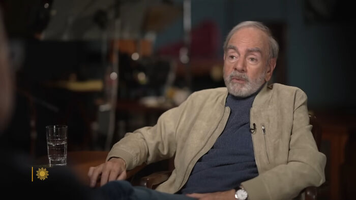 Older man with gray beard and casual jacket speaking in an interview setting about celebrities people think suffer.