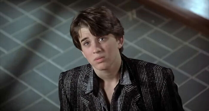 Young man in a striped jacket looking up thoughtfully, representing themes of once famous regular job and life changes.