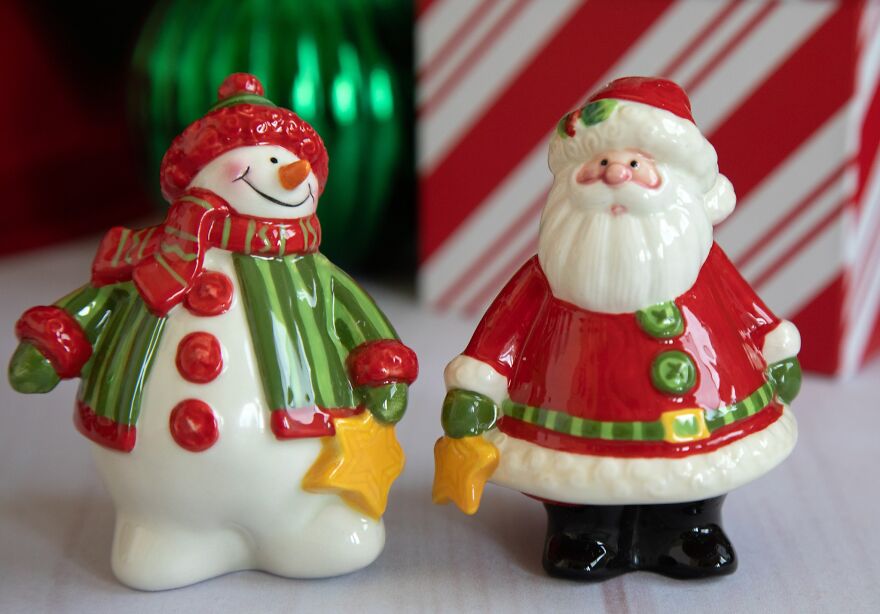 Nostalgic vintage Christmas decorations featuring a ceramic snowman and Santa Claus figurines with holiday scarves.