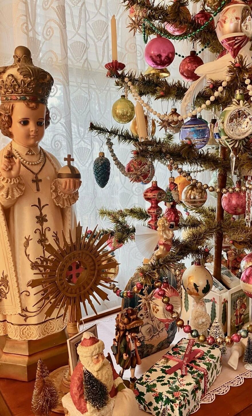 Vintage Christmas decorations including colorful glass ornaments, Santa figurines, and nostalgic holiday decor on a decorated tree.