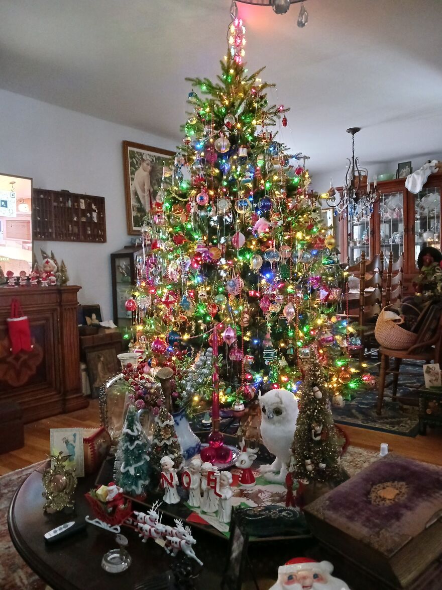 Vintage Christmas decorations with colorful lights and nostalgic ornaments around a decorated holiday tree in a cozy living room.