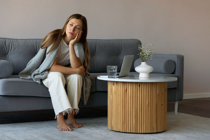 Woman on a couch looking shocked and contemplative after being asked to be the wedding photographer for free. Woman on a couch looking shocked and contemplative after being asked to be the wedding photographer for free.