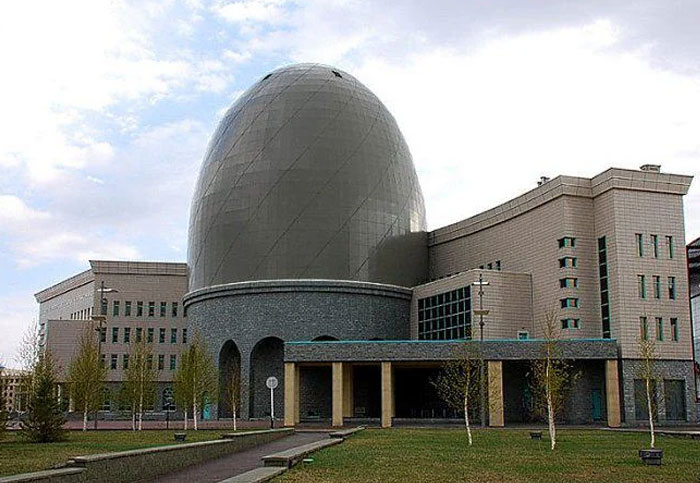 Bread-shaped bread factory building with a large dome and modern architectural design under a cloudy sky.