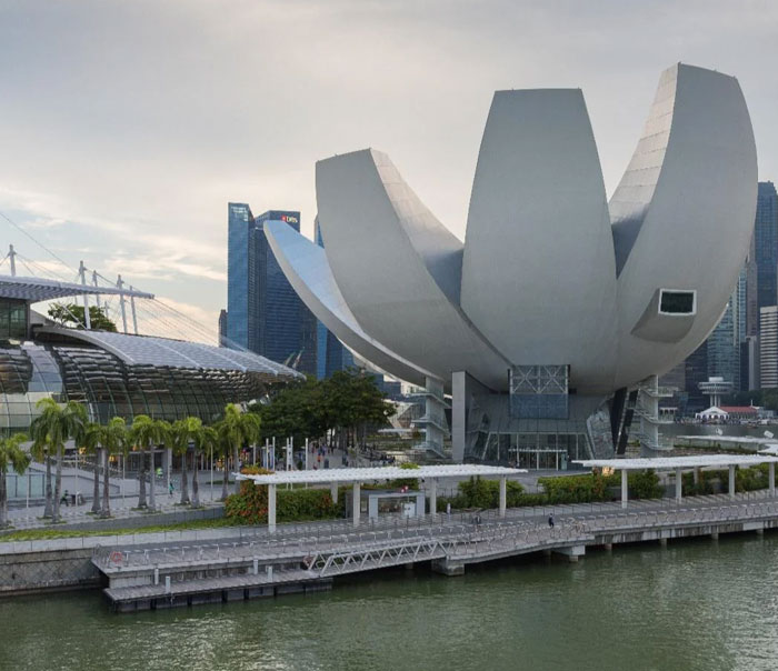 Modern building with unique architectural design resembling a bread-shaped bread factory near waterfront cityscape.