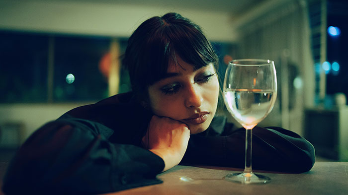 Woman looking upset and thoughtful during Thanksgiving dinner, reflecting on tension with brother-in-law clapping back. Woman looking upset and thoughtful during Thanksgiving dinner, reflecting on tension with brother-in-law clapping back.