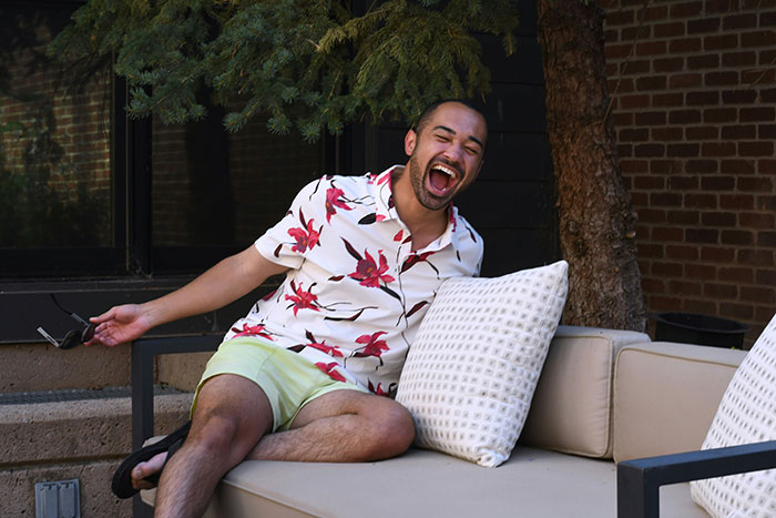 Man laughing outdoors in floral shirt and shorts, capturing the mood of a woman clapping back at BIL during Thanksgiving dinner. Man laughing outdoors in floral shirt and shorts, capturing the mood of a woman clapping back at BIL during Thanksgiving dinner.