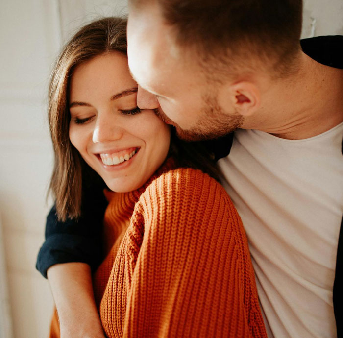 Woman smiling while man affectionately kisses her, illustrating themes of proof and cheating in relationships. Woman smiling while man affectionately kisses her, illustrating themes of proof and cheating in relationships.