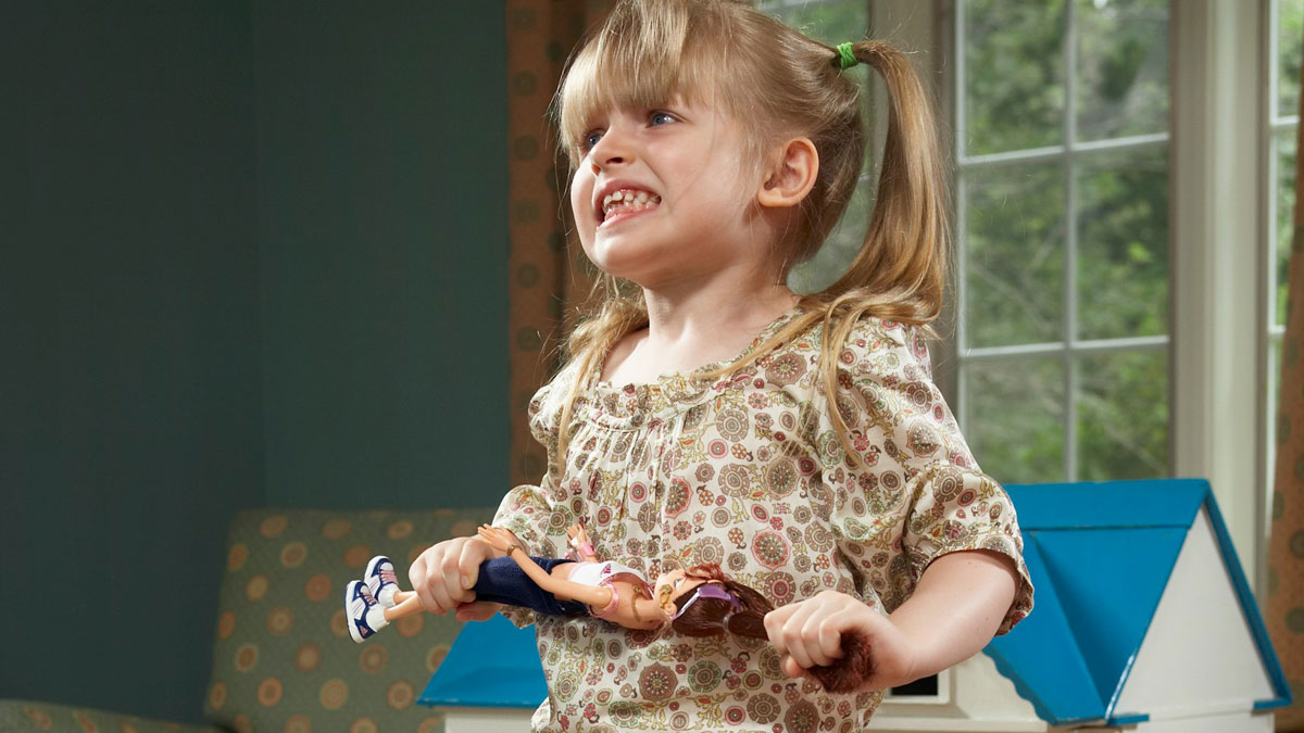 Young girl showing angry behavior indoors, illustrating stepdaughteru2019s difficult behavior and family conflicts.