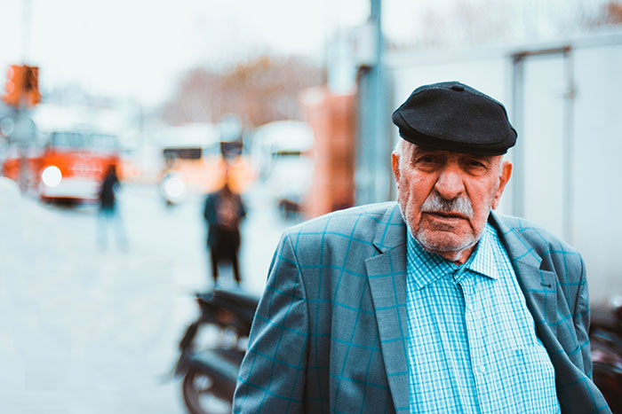 Older man in a Goodwill store wearing a cap and jacket, representing generational conflict and criticism of younger generations. Older man in a Goodwill store wearing a cap and jacket, representing generational conflict and criticism of younger generations.