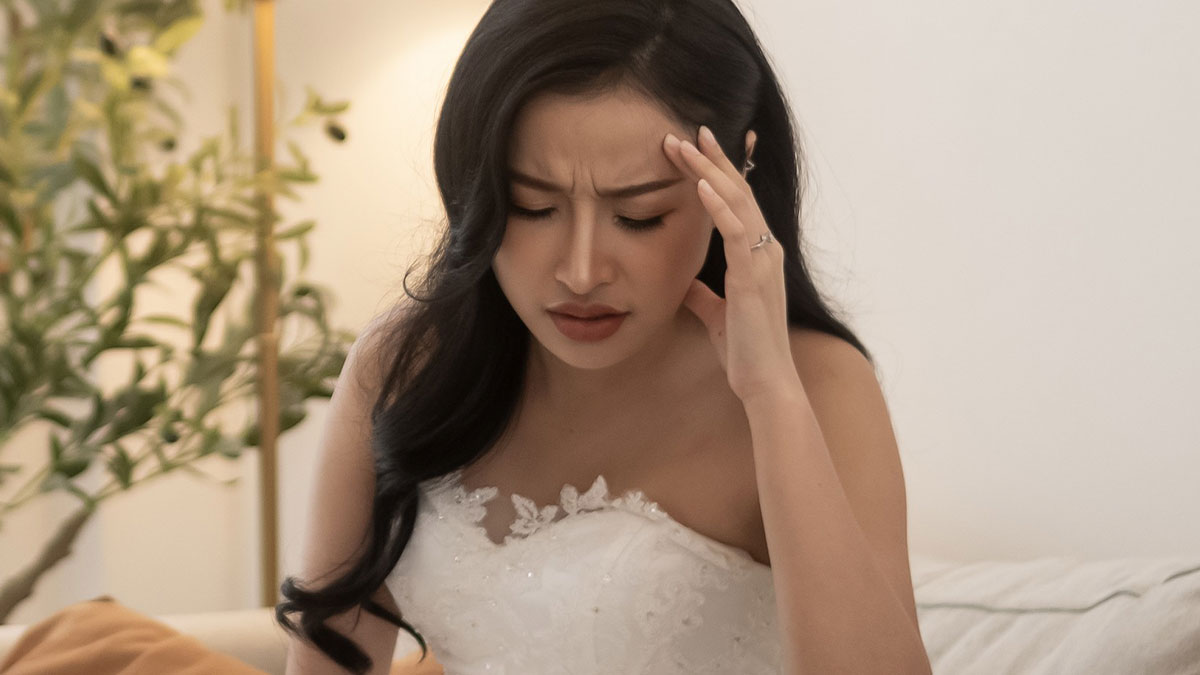 Bride in wedding dress looking distressed and seeking support after couple split at altar revelations.